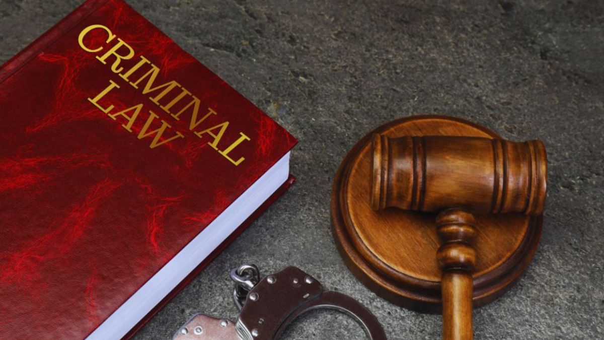 Blogs 4 Criminal law textbook, wooden judge’s gavel, and metal handcuffs on a dark stone surface symbolizing criminal defense legal services in Fort Lauderdale, Florida.